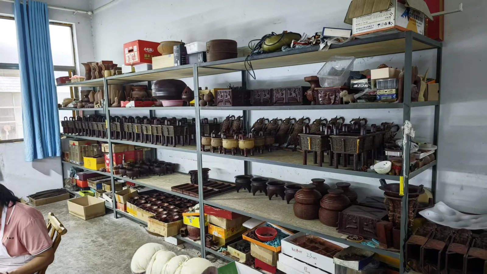 Bronze vessel forms arranged on shelves in the workshop showroom