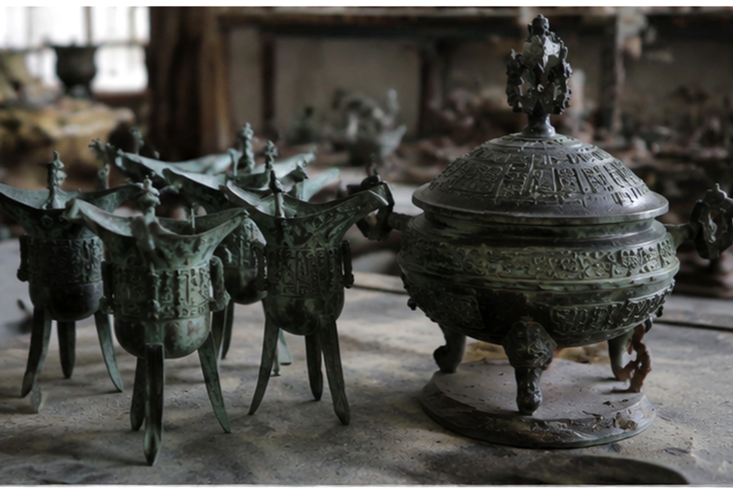 Bronze Jue cups and an incense burner grouped on a Luoyang workshop table